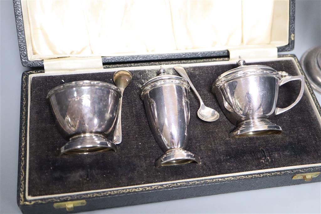 A cased modern silver three piece condiment set with two spoons and a George V silver spill vase, 18.4cm, weighted.